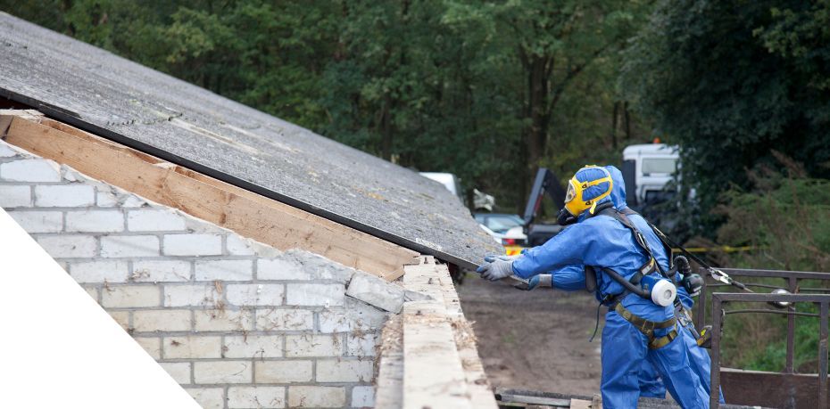 Photo of hazmat workers with gear on removing asbestos from roof