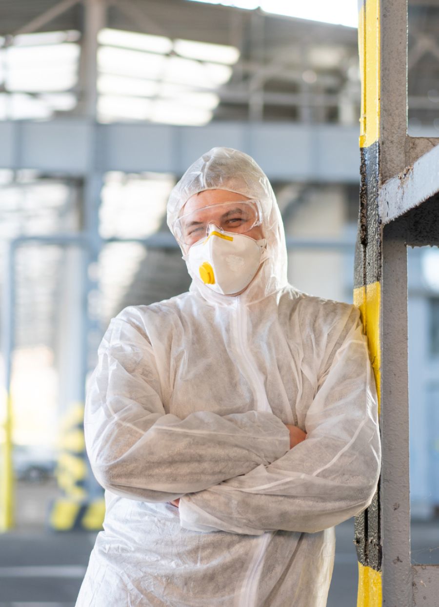 Construction worker looking at comera in work clothing and arms crossed