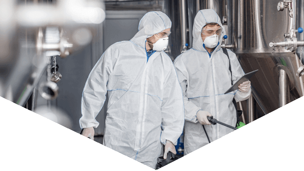 Hero image of Hazmat worker looking at camera with equipment in a triangular shape