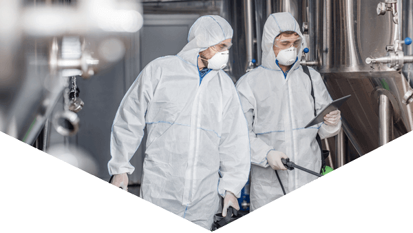 Hero image of Hazmat worker looking at camera with equipment in a triangular shape